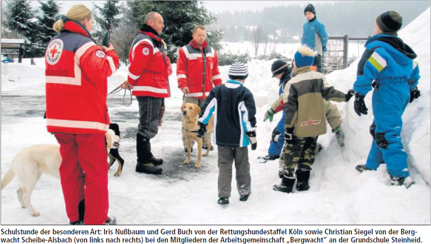 Schulstunde der besonderen Art: Iris Nußbaum und Gerd Buch von der Rettungshundestaffel Köln sowie Christian Siegel von der Bergwacht Scheibe-Alsbach (von links nach rechts) bei den Mitgliedern der Arbeitsgemeinschaft „Bergwacht“ an der Grundschule Steinheid.